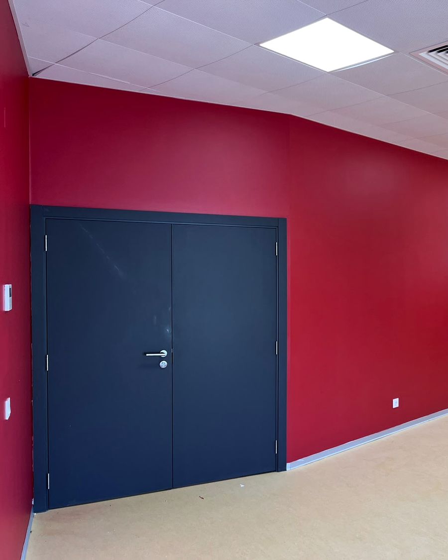 Sala com paredes pintadas a vermelho e pavimento em rolo claro